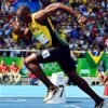 alt="Usain Bolt smiling before 100m sprint"