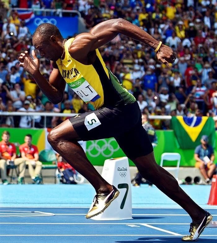 alt="Usain Bolt smiling before 100m sprint"