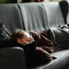 woman in pink jacket lying on gray couch. The Attention Economy