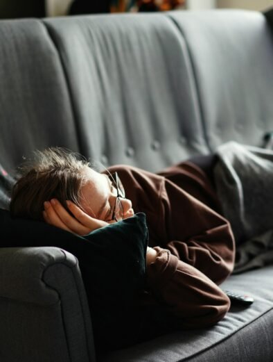 woman in pink jacket lying on gray couch. The Attention Economy