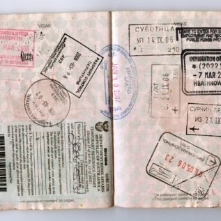 Passport pages with visa and immigration stamps, a reminder to check US entry limits before you apply